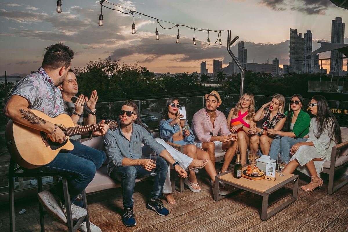 Grupo celebrando en la terraza de Eolian con la ciudad de fondo